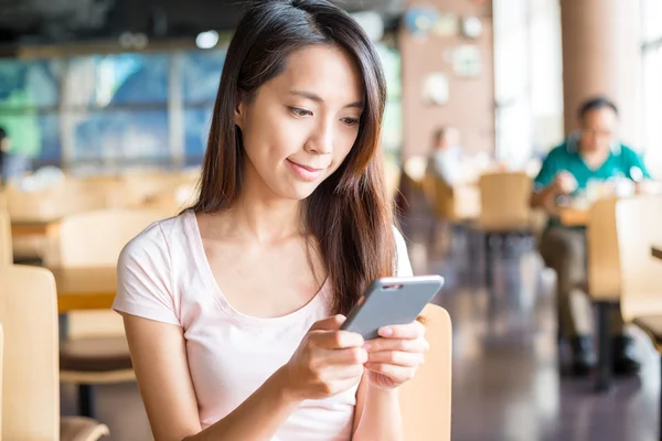 Woman using smart phone at indoor cafe — Stock Photo, Image
