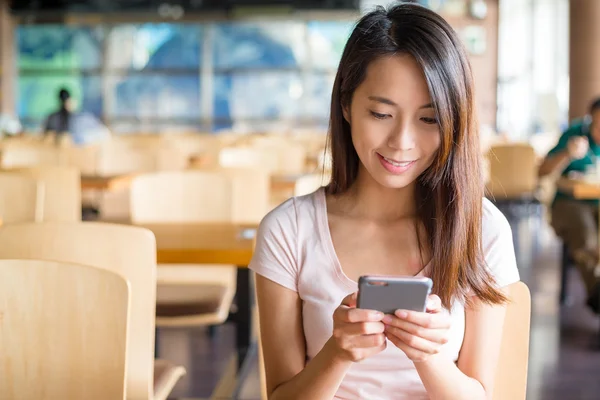 Kvinna med smart-telefonen på inomhus café — Stockfoto