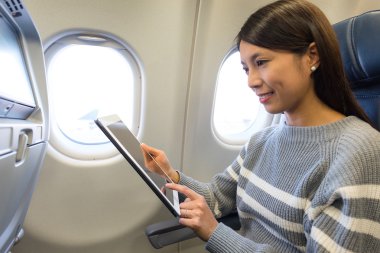 Tablet içinde uçak kullanan kadın