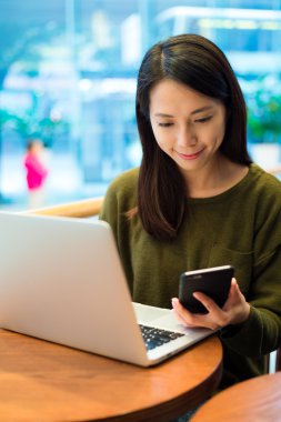 Dizüstü bilgisayar ve cep telefonu kullanan kadın 