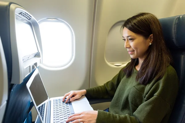 Mujer que trabaja con el ordenador portátil dentro del avión — Foto de Stock