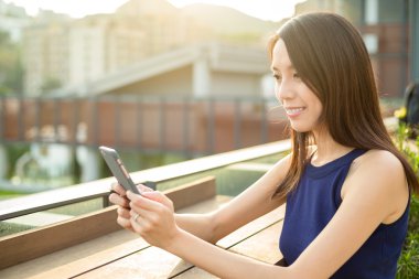 Açık café'de cep telefonu kullanan kadın