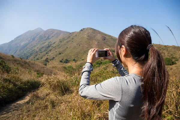 Kvinnan tar bilder under vandring resa — Stockfoto