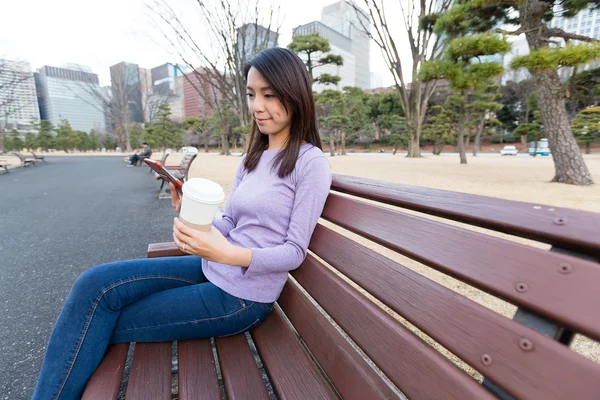 Donna che utilizza il cellulare al parco — Foto Stock