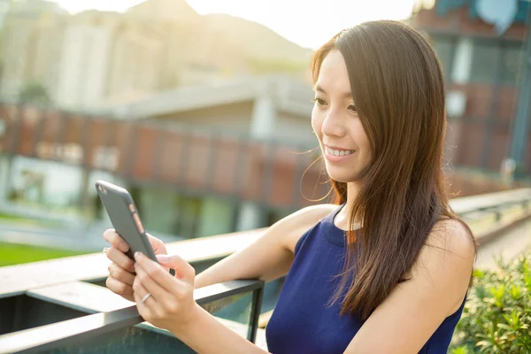 Kvinna med hjälp av mobiltelefon på uteservering — Stockfoto