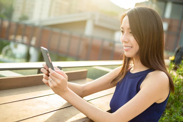 Vrouw met behulp van mobiele telefoon op buiten bij zonsondergang — Stockfoto