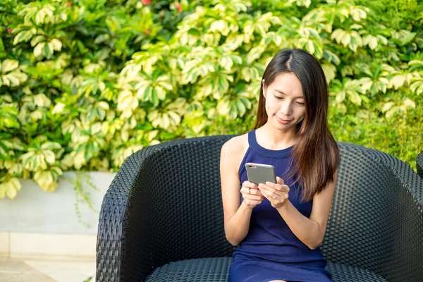 Woman using cellphone at outdoor coffee shop