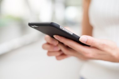 Kadın cep telefonuna bakıyor.