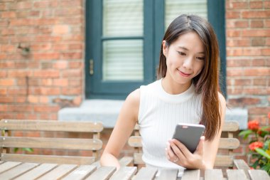 Açık café'de cep telefonu kullanan kadın