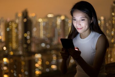 Geceleri cep telefonu kullanan kadın