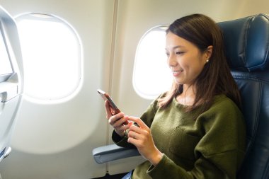 Hareket eden telefon içinde uçak kullanan kadın