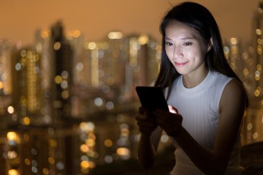 Geceleri cep telefonu kullanan kadın 