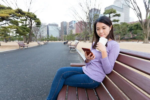 Woman using cellphone at outdoor park — Stock Photo, Image