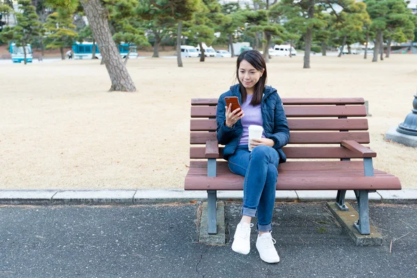 Femme utilisant un téléphone portable au parc extérieur — Photo