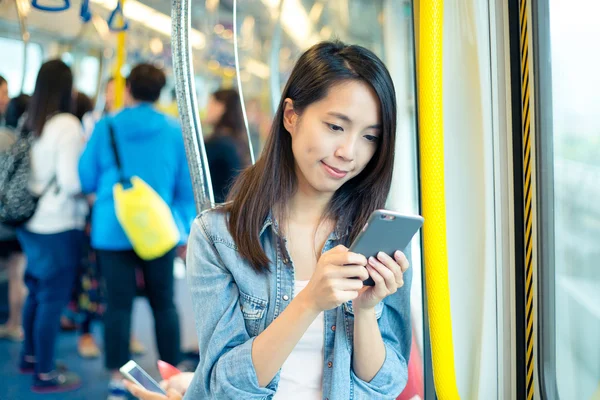 Mujer usando teléfono móvil dentro del tren — Foto de Stock