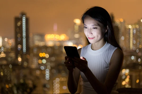 Mujer usando el teléfono celular por la noche — Foto de Stock