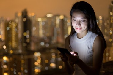 Geceleri cep telefonu kullanan kadın