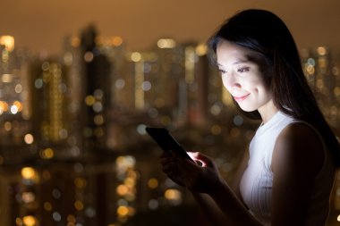 Geceleri cep telefonu kullanan kadın 