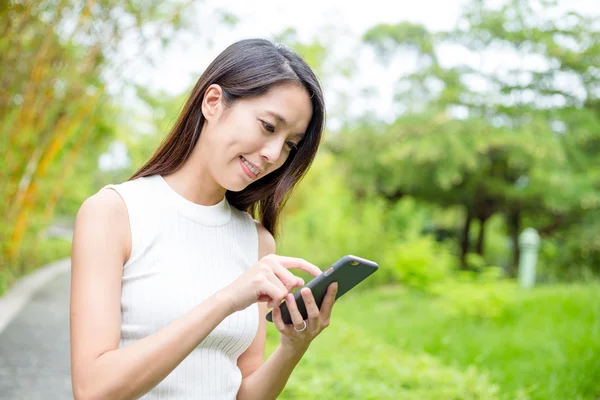 Vrouw met behulp van slimme telefoon bij buiten — Stockfoto