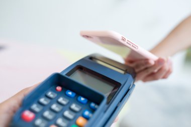 Fatura ödeme için cep telefonu kullanan kadın