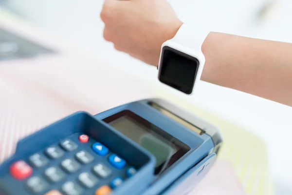 Mujer pagando la cuenta con un reloj inteligente — Foto de Stock