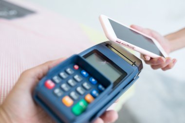 Fatura ödeme için cep telefonu kullanan kadın