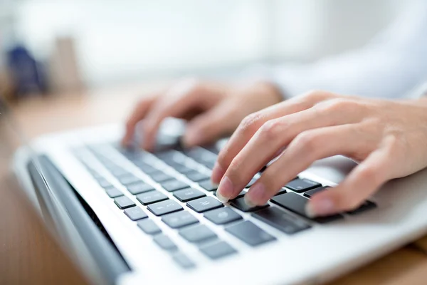 Manos femeninas escribiendo en el ordenador portátil Imagen de stock