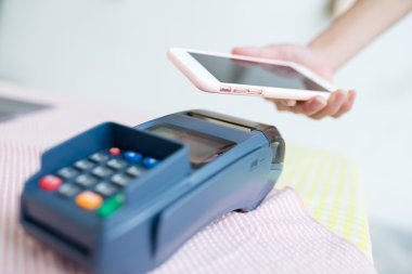 Fatura ödeme için cep telefonu kullanan kadın