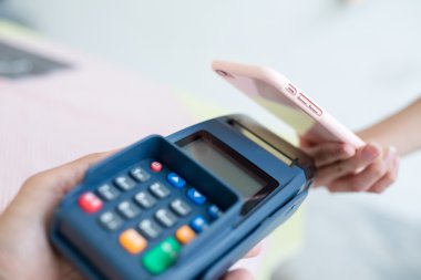 Fatura ödeme için cep telefonu kullanan kadın