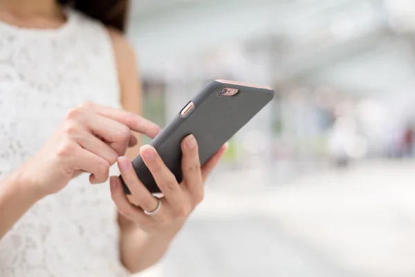 Vrouw met behulp van de mobiele telefoon voor sms — Stockfoto