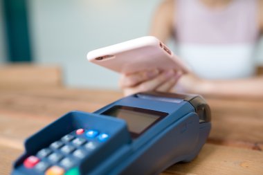 Fatura ödeme için cep telefonu kullanan kadın