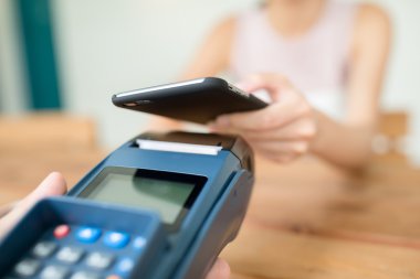 Fatura ödeme için cep telefonu kullanan kadın