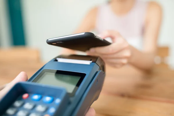 Kobieta za pomocą telefonów komórkowych za zapłacenie rachunku — Zdjęcie stockowe
