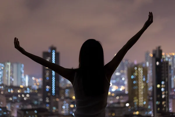 Woman raising hands and looking the city — Stock Photo, Image