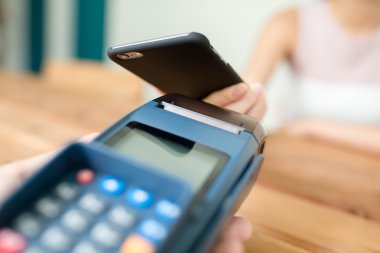 Kadın çıkış tarafından cep telefonu üzerinde pos terminal