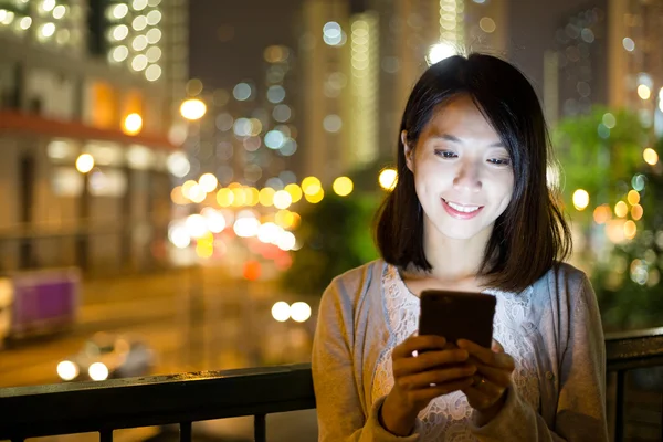 Mulher usando telefone celular à noite — Fotografia de Stock