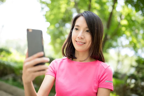 Frau benutzte Handy im Park — Stockfoto