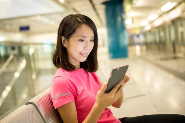 Žena pomocí smartphonu na vlakovém nádraží — Stock fotografie
