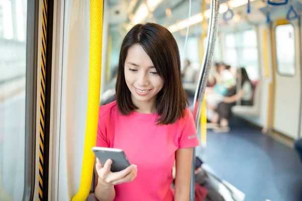 Žena použití mobilního telefonu uvnitř vlaku — Stock fotografie