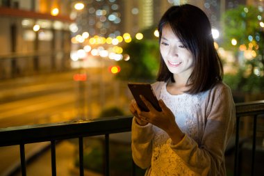 Geceleri cep telefonu kullanan bir kadın.