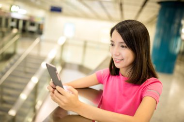 Tren istasyonunda cep telefonu kullanan kadın