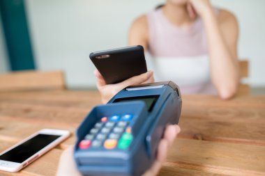 Fatura ödeme için cep telefonu kullanan kadın