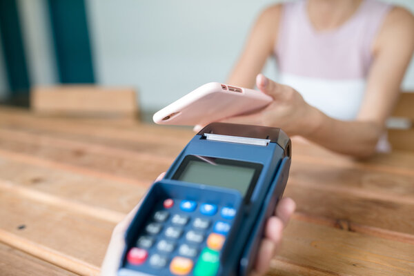 Woman using cellphone for paying the bill
