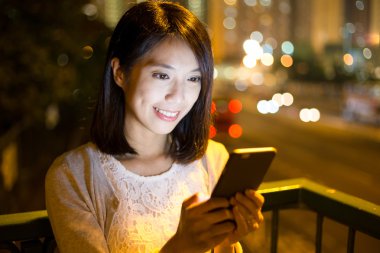 Geceleri cep telefonu kullanan bir kadın.