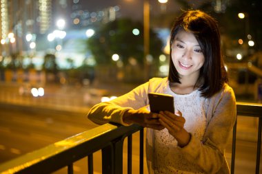 Geceleri cep telefonu kullanan bir kadın.