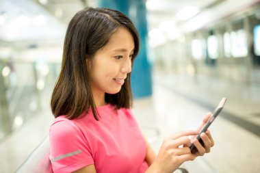 Tren istasyonunda cep telefonu kullanan kadın