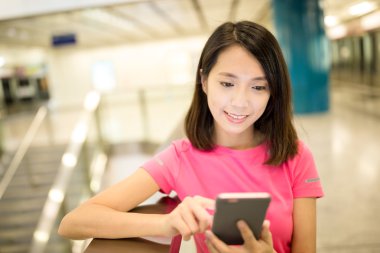 Tren istasyonunda cep telefonu kullanan kadın