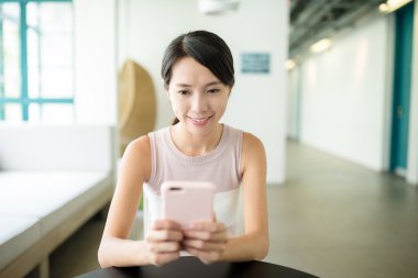 Kafede cep telefonu kullanan kadın