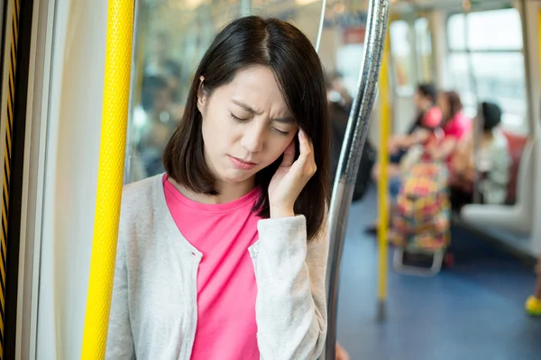 Kobieta uczucie ból głowy wewnątrz pociągu — Zdjęcie stockowe