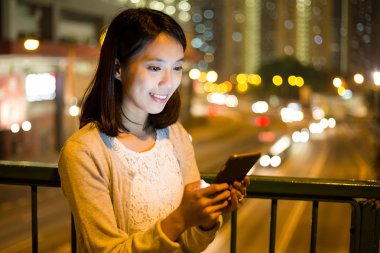 Akşamları akıllı telefon kullanan kadın.